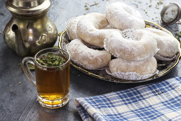 Oriental Algerian sweet cookies( gazelle horns cookies ), tea cup and pot  and mint leaves