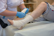 © Светлана Лазаренко - .Nurse bandages a patient's leg