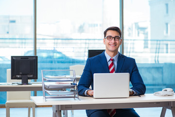 Young handsome businessman employee working in office at desk