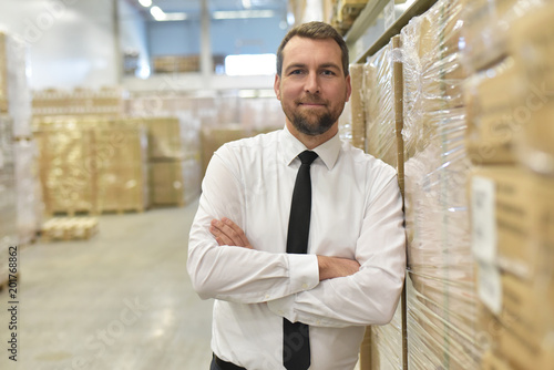 Cuadros en Lienzo Portrait lächelnder Geschäftsmann/ Unternehmer im Warenlager einer Spedition //