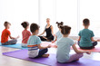 © New Africa - Little children and their teacher practicing yoga in gym