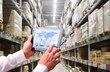 © sittinan - manager hand holding tablet with AR application for check order pick time in smart factory warehouse,  connection for Logistic Import Export ,interior of warehouse. Rows of shelves with boxes