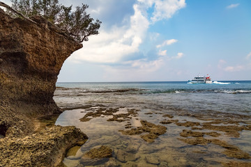 Scenic Neil Island sea beach Andaman with corals and natural rock formations and view of a cruise ship at the horizon.