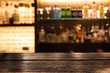 © Kritchanon - Empty dark wooden bar counter with blur background bottles of restaurant.