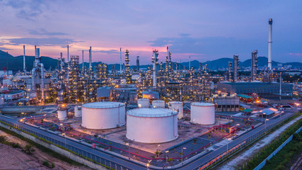 Wall Mural - Aerial view oil and gas business chemical tank with oil refinery plant background at twilight.