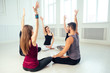 © yurakrasil - a happy group of people from men and women practicing yoga in the studio. groups of meditation , communication yoga class. the concept of group meditation and teamwork. coach and students in a circle