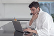 © FS-Stock - A man in a robe with a laptop at home