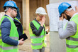 © Ivan - Team of successful young engineers and business partners facing problems during a meeting on a construction site. Looking at blueprints.