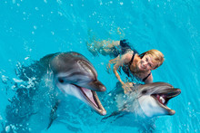 Coach Swims In The Water With Dolphins. Dolphin Assisted Therapy.