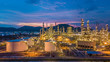 Aerial view oil and gas storage chemical tank with oil refinery petrochemical construction architecture plant background at twilight.