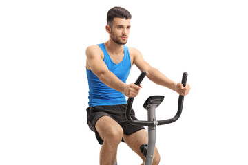 Poster - Young man exercising on a stationary bike