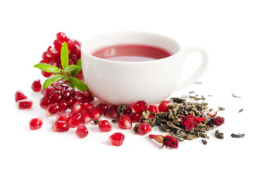 Wall Mural - Parts of a pomegranate with pomegranate seeds and leaves, flowers, dry tea of carcade and full cup of tea isolated on white background