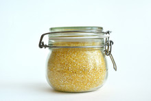 Yellow Corn Groats In A Glass Jar On A White Background