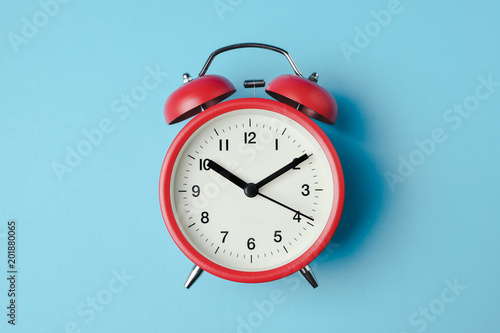 Fotomural Red vintage alarm clock on light blue color background