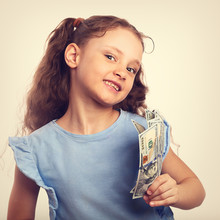 Happy Laughing Rich Kid Girl Holding Money Hand On Empty Copy Space Toned Vintage Background
