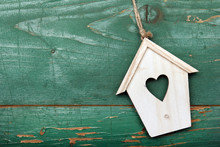 Small Wooden Bird House With Heart Decoration On Green Retro Wooden Background, Copy Space.