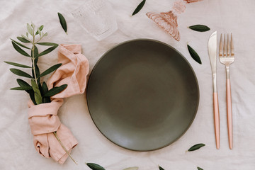 Canvas Print - Empty plate with rustic decorations. Wedding table set with linen napkin and olive branch. Top view