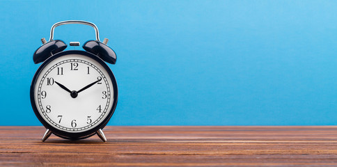 Wall Mural - alarm clock on a color background on a wooden board