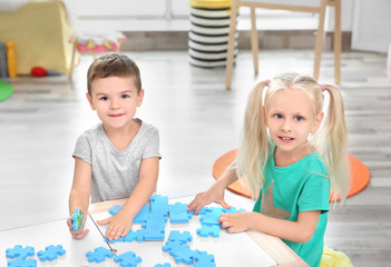 Canvas Print - Cute little children playing with puzzle at home