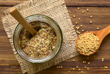 Whole Grain Mustard In Glass Jar, Photographed Overhead On Wood Natural Light (Selective Focus, Focus On The Top Of The Mustard)