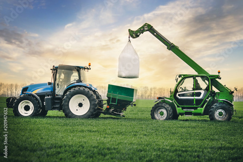 fertilizers are carried in a sacks on the tractor trailer in the field in the...