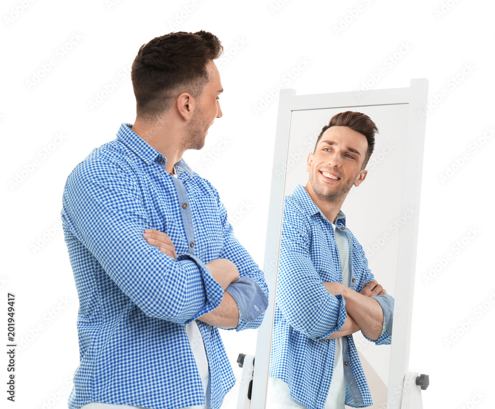 Young man looking at himself in mirror on white background - obrazy, fototapety, plakaty 