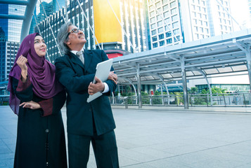 Two Muslim businessmen and women look for sucessl with city background, muslim business Concept