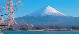 Mount Fuji with snow capped, blue sky and beautiful Cherry Blossom or pink Sakura flower tree in Spring Season at Lake kawaguchiko, Yamanashi, Japan. landmark and popular for tourist attractions