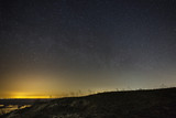 Fototapeta Na sufit - Bright stars in the night sky against the backdrop of the hills. Landscape with a long exposure.