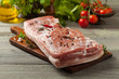 Raw bacon in whole on wooden background.