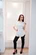 © AS Photo Family - Brunette gorgeous girl in the clothing store boutique at casual clothes, white blouse and black pants.