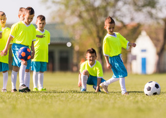 Wall Mural - Young children players football match on soccer field