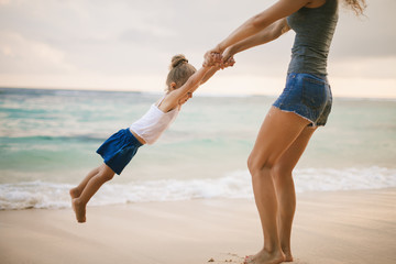 Mom and baby playing near beach. Traveling with family, child