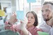 © pressmaster - Business couple standing in front of glass wall with post it notes and discussing