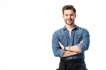 Wall Mural - portrait of smiling waiter in apron with arms crossed isolated on white