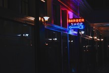 Neon Barbershop Sign Illuminated At Night