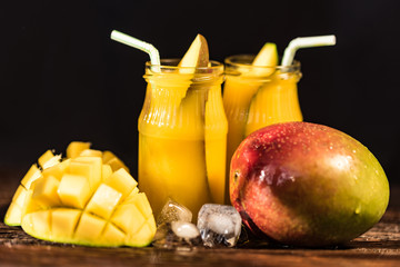 Mango juice and mango on wood table