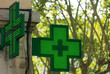Closeup of a green pharmacy sign outside a pharmacy store in France.