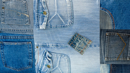 Background texture of denim fabric with pockets and stitched seams with buttons and rivets from different pieces of jeans.