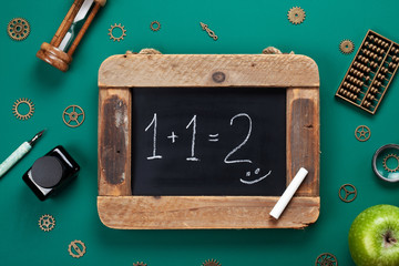 Retro school accessories with math problem on old chalkboard. Back to school concept