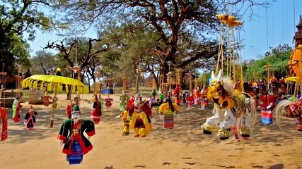 Poster - Traditional handicraft market in Bagan - handmade toys, puppets and bright umbrellas hang on the strings from the trees around the ancient temples in archaeological site, Myanmar.