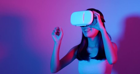 Wall Mural - Woman watching with VR headset with cyber lighting