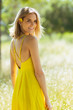 © Jeremy Francis - Attractive young blonde Caucasian woman in thin yellow sun dress with flowers in hair posing outside near grass and trees