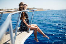 Young Beautiful Woman Lying On The Deck Of A Yacht At Sea.