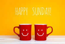 Two Red Coffee Mugs With A Smiling Faces On A Yellow Background With Copy Space.