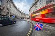 London, England - Iconic red double-decker bus and black taxi on the move on Regent Street with british umbrella