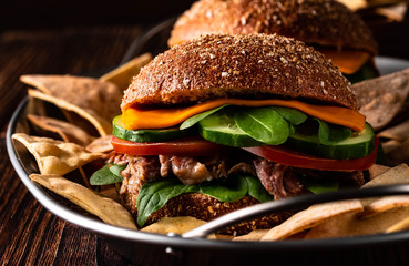 American rustic burger with cheddar, beef, salad and vegetable and original homemade nachos with honey mustard dip, place for advertising.