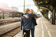 © Maskot - Couple hugging at train station