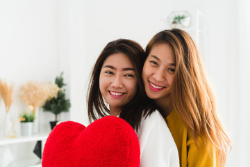 Wall Mural - Beautiful young asian women LGBT lesbian happy couple sitting on bed hugging and smiling together in bedroom at home. LGBT lesbian couple together indoors concept. Spending nice time at home.