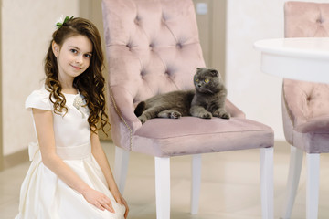 A cute little girl spends her time with her sweet cat